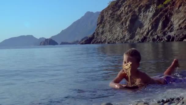 Un niño se juega en la playa — Vídeos de Stock