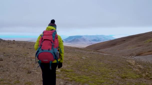 Жінка з рюкзаком ходить в горах — стокове відео