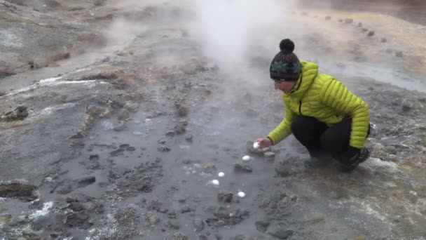 Una donna cucina uova in una sorgente calda — Video Stock