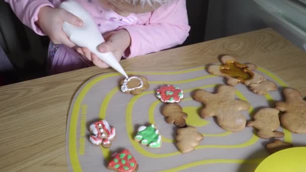 Child paints Christmas cookies. — ストック動画