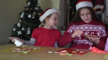 Çocuklar Noel kurabiyelerini süslerler.