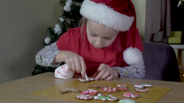 Kind bemalt Weihnachtsplätzchen. — Stockvideo