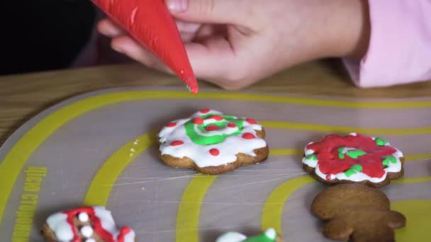 Child paints Christmas cookies. — ストック動画