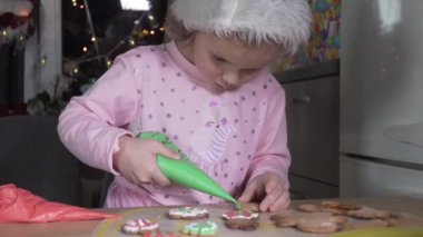 Child paints Christmas cookies.