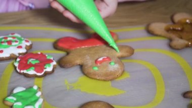 Child paints Christmas cookies.