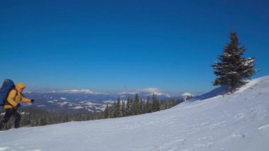 Sırt çantalı turist kar manzarasında yürüyor.
