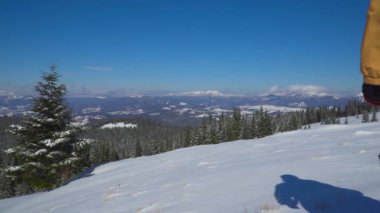 Sırt çantalı turist kar manzarasında yürüyor.