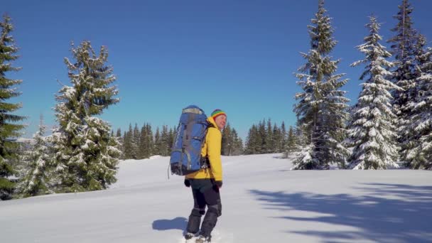 Hombre mochilero turista caminando nieve paisaje — Vídeo de stock
