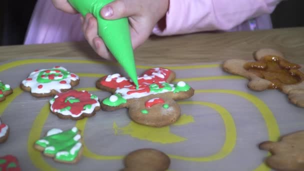 Child paints Christmas cookies. — ストック動画