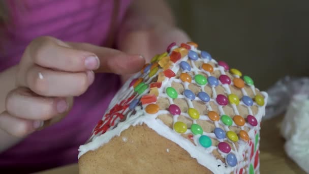 Dziewczyna ozdabia świąteczny domek z piernika — Wideo stockowe