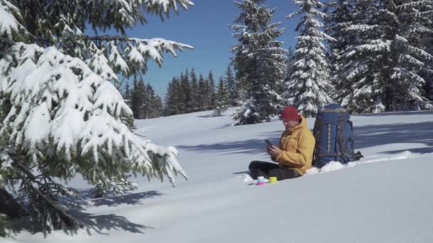 Turistsamtal på telefon i vinterskogen — Stockvideo