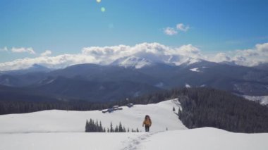 Sırt çantalı bir adam kışın dağlarda seyahat eder.
