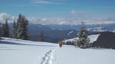 Sırt çantalı bir adam kışın dağlarda seyahat eder.