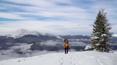 Sırt çantalı bir adam kışın dağlarda seyahat eder.