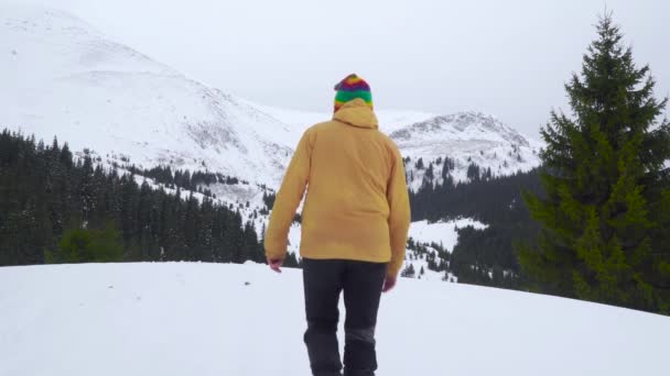 Un hombre viaja en las montañas en invierno — Vídeos de Stock