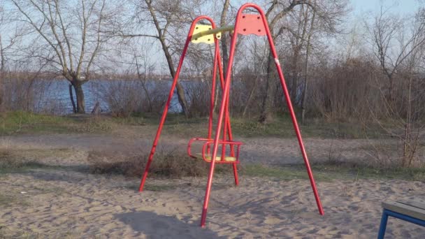 Columpios vacíos en el patio de recreo — Vídeo de stock