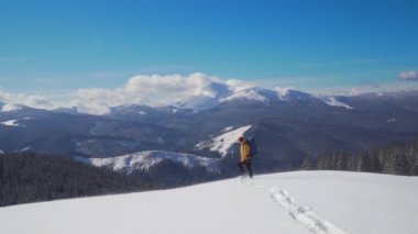 Sırt çantalı bir adam kışın dağlarda seyahat eder.