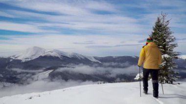 Bir adam kışın dağlarda seyahat eder.
