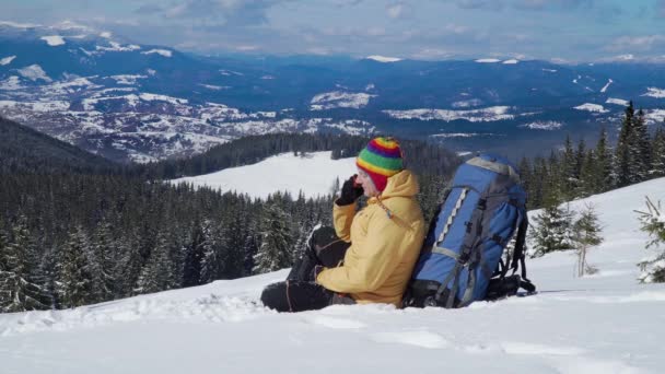 Туристические переговоры по телефону в горах зимой — стоковое видео