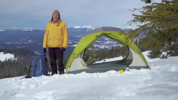 Путешественник возле палатки в горах — стоковое видео