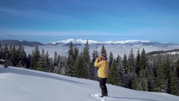 Un homme boit du thé sur un fond de paysage des Carpates en hiver — Video