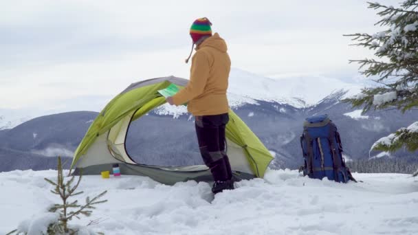 Путешественник возле палатки в горах — стоковое видео
