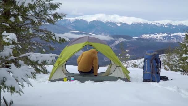 Turista relaxa em uma tenda nas montanhas no inverno — Vídeo de Stock