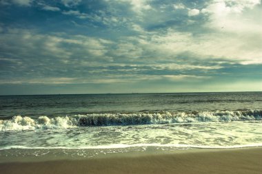 Deniz kıyısı, dalgalar ve bulutlar gökyüzünde