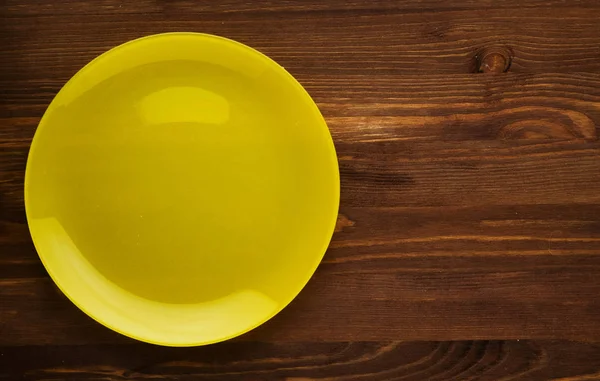 Plate on a wooden background.yellow plate . plate top view. cop — Stock Photo, Image