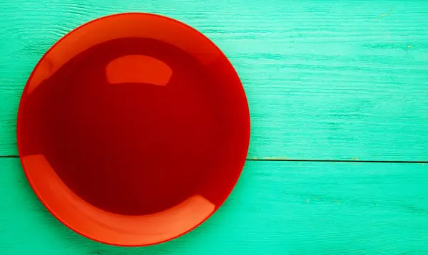 Plate on a wooden background.red plate . plate top view. copy — Stock Photo, Image