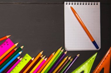 Okul malzemeleri (kurşun kalem, kalem, cetvel, üçgen) yazı tahtası üzerinde bac