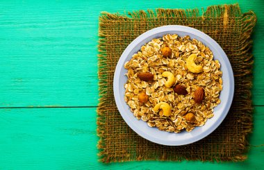   (fındık, kaju fıstığı, badem) Fındıklı müsli. müsli ahşap bir masa üzerinde. müsli üstten görünüm. sağlıklı gıda 