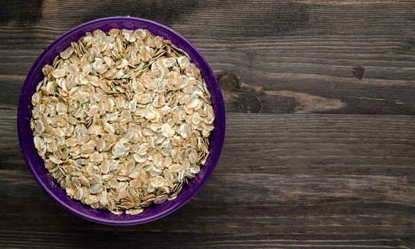 Havermout op een houten tafel. Havermout bovenaanzicht. Gezonde voeding . — Stockfoto