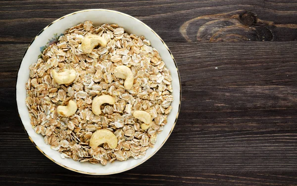 Oatmeal with nuts cashews. Oatmeal on a wooden table. Oatmeal t — Stock Photo, Image