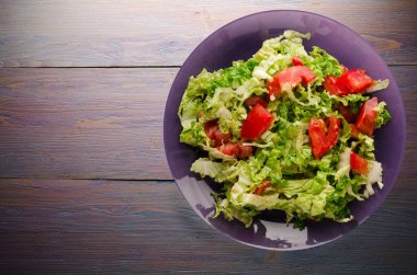  ahşap arka plan üzerinde bir tabakta lahana domates salatası