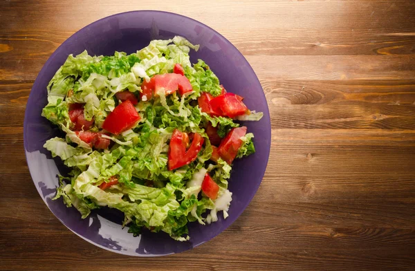 Ahşap arka plan üzerinde bir tabakta lahana domates salatası — Stok fotoğraf