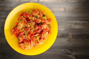 Ahşap arka plan üzerinde bir tabak içinde soğan ile haşlanmış domates 