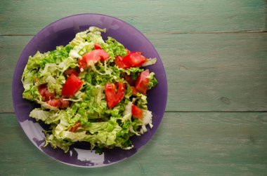  ahşap arka plan üzerinde bir tabakta lahana domates salatası