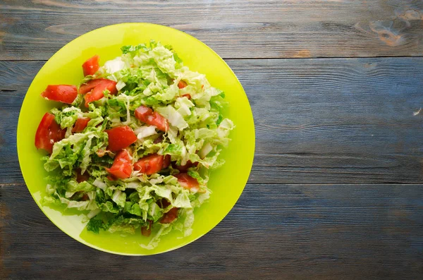  ahşap arka plan üzerinde bir tabakta lahana domates salatası