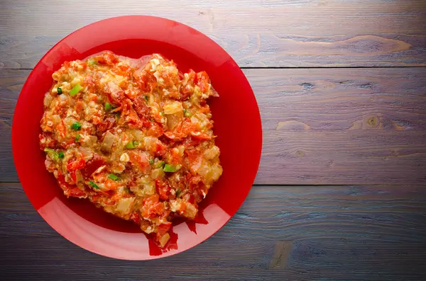 Soğanlı bir ahşap bir tabağa haşlanmış domates  