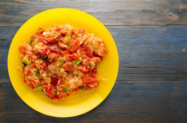 Ahşap arka plan üzerinde bir tabak içinde soğan ile haşlanmış domates 