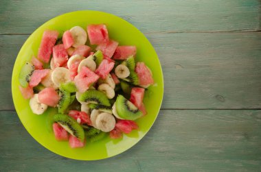 sağlıklı taze meyve salatası ahşap zemin üzerine tabak 