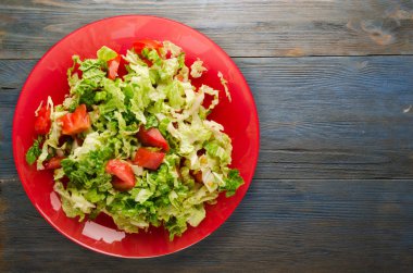  ahşap arka plan üzerinde bir tabakta lahana domates salatası