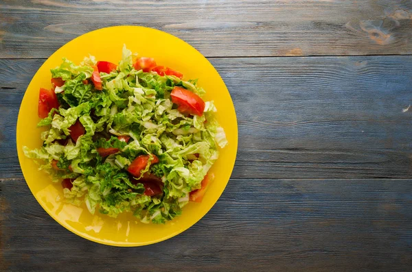 Ensalada de tomate de col en un plato sobre un fondo de madera — Foto de Stock