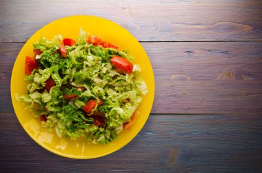  ahşap arka plan üzerinde bir tabakta lahana domates salatası