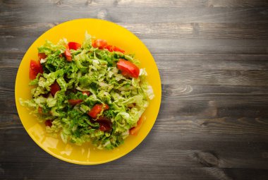  ahşap arka plan üzerinde bir tabakta lahana domates salatası