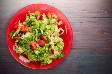  ahşap arka plan üzerinde bir tabakta lahana domates salatası