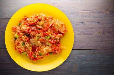 Ahşap arka plan üzerinde bir tabak içinde soğan ile haşlanmış domates 