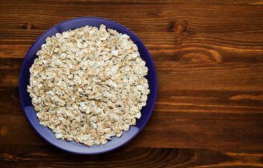  Ahşap bir masa üzerinde yulaf ezmesi. Yulaf ezmesi üstten görünüm. Sağlıklı gıda .