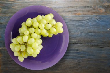 ahşap arka plan üzerinde üzüm. bir plaka üzerinde üzüm